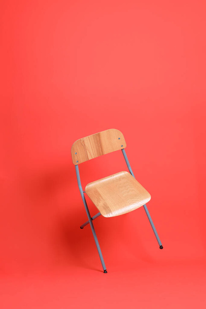 Az elszigetelt szék lebeg a narancssárga háttér. - Fotó, kép