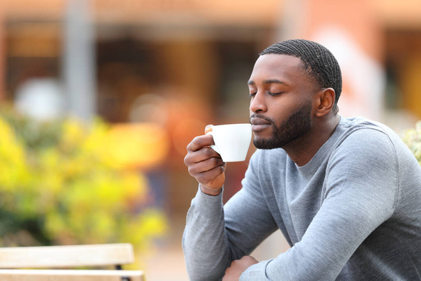 Man with black skin relaxing drinking coffee in a bar terrace - Fotoğraf, Görsel