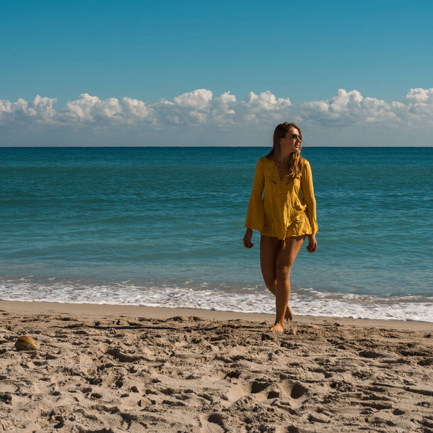 Gyönyörű fiatal nő napszemüvegben a strandon - Fotó, kép