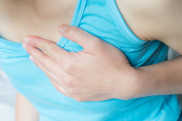 Close-up de mulher com dor no peito ou ataque cardíaco. Conceptual de doença cardíaca ou dor no peito pode indicar um problema grave, é importante procurar ajuda médica imediata. - Foto, Imagem