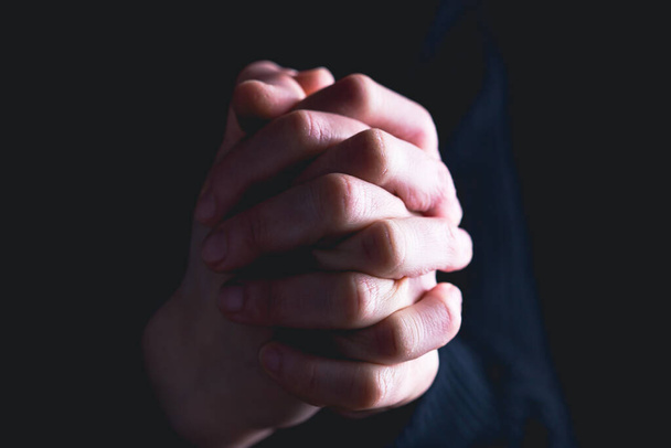 Praying hands with faith in religion and belief in God on dark background. Power of hope or love and devotion. - Photo, image