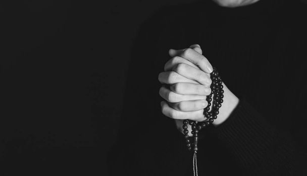 Religious young woman praying to God, on dark background. - Foto, Imagen