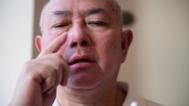 Un hombre maduro que sufre de fiebre del heno aplicando un aerosol nasal para aliviar los síntomas de bloqueo de la nariz y estornudos. - Imágenes, Vídeo