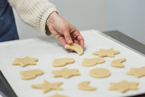 Snoepgoed snijden deeg met verschillende vormen tijdens het maken van koekjes in de keuken van de bakkerij. - Foto, afbeelding