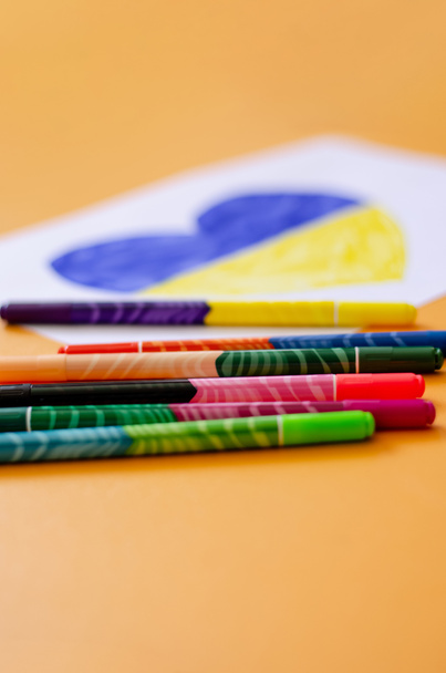 modern felt pens near blurred paper with drawn heart and ukrainian flag on yellow  - Photo, Image
