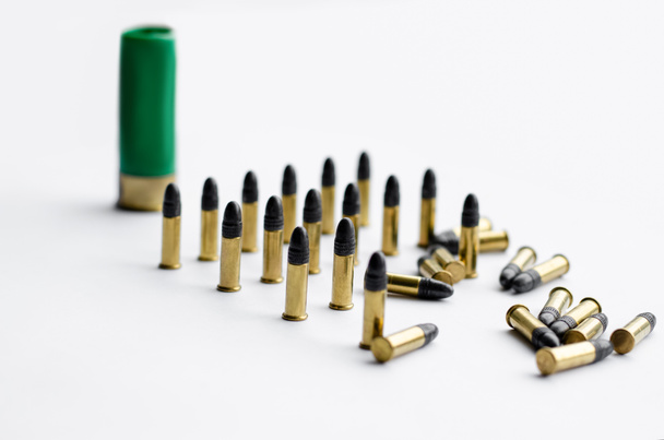 balas cerca del cartucho borroso de la escopeta sobre fondo blanco  - Foto, imagen