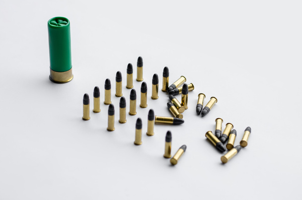 same caliber bullets near shotgun shell on white  - Valokuva, kuva