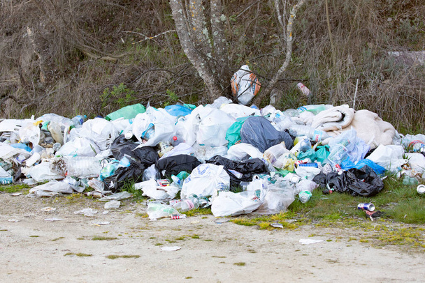 Um depósito de lixo num campo rural. Paisagem poluída. Lixo no lugar errado é um problema ambiental.  - Foto, Imagem