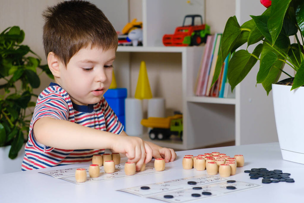 Un garçon de 4 ans joue au loto, étudie les nombres à l'aide d'un jeu de société - Photo, image