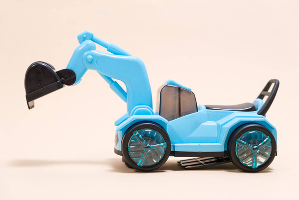 Μπλε εκσκαφέας πλαστικό μηχάνημα σε λευκό φόντο. Αυτοκίνητο μηχανημάτων εργοταξίου για σκάψιμο σε κατάστημα παιχνιδιών και παιδιά - Φωτογραφία, εικόνα