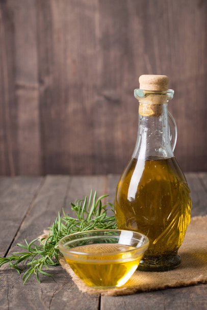 Rosemary oil on wooden background. Natural food concept.  - 写真・画像