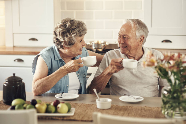Une bonne tasse de café donne le ton pour la journée. Tourné d'un couple de personnes âgées prenant le petit déjeuner ensemble à la maison. - Photo, image