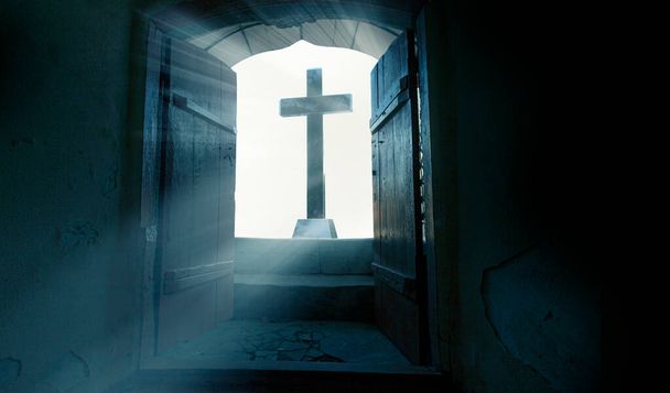 The Resurrection of Jesus Christ. Religious Easter background, with strong light rays shining through the entrance to an empty stone tomb. - Photo, Image