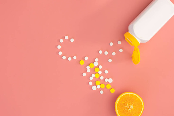 Scattered pills on a pink background, flat lay. - Foto, Bild