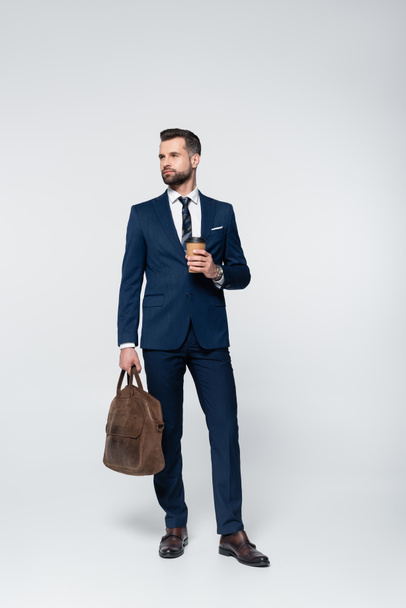 full length view of economist with leather briefcase and coffee to go on black - Photo, Image