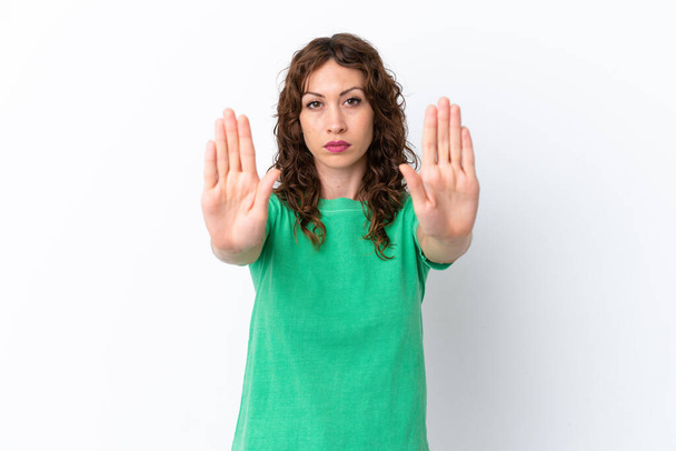 Young woman with curly hair isolated on white background making stop gesture and disappointed - Photo, Image