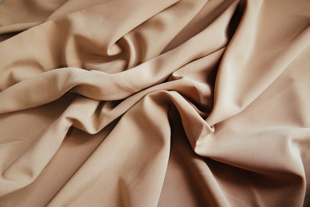 Beige fabric for drapery. A piece of matter with folds. Crumpled Texture - 写真・画像