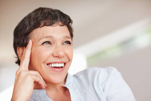 Happy moments. Closeup of happy mature woman smiling while looking away. - 写真・画像