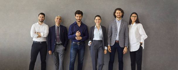 Banner with group portrait of successful business professionals leaning on grey wall - Foto, Imagem
