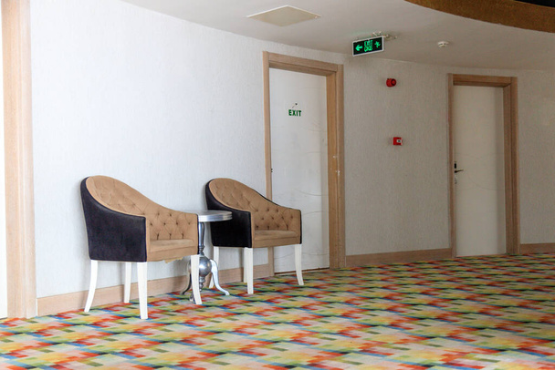 Кресла в стиле модерн стоят между номерами в коридоре турецкого отеля - Фото, изображение
