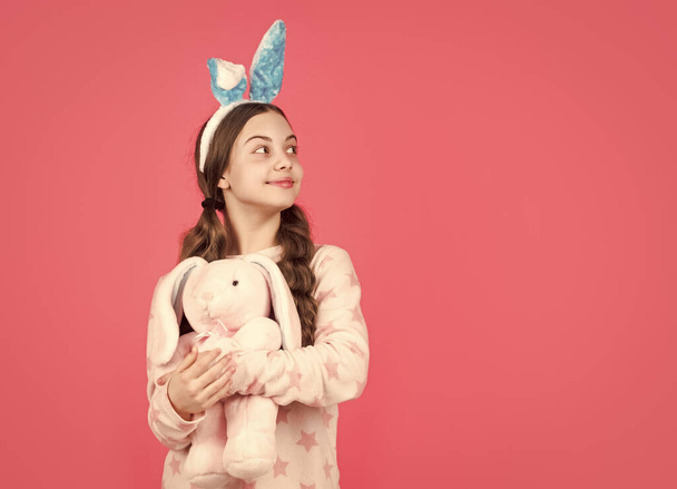 happy easter child girl in bunny rabbit ears and pajamas play with toy, copy space, easter - Фото, зображення