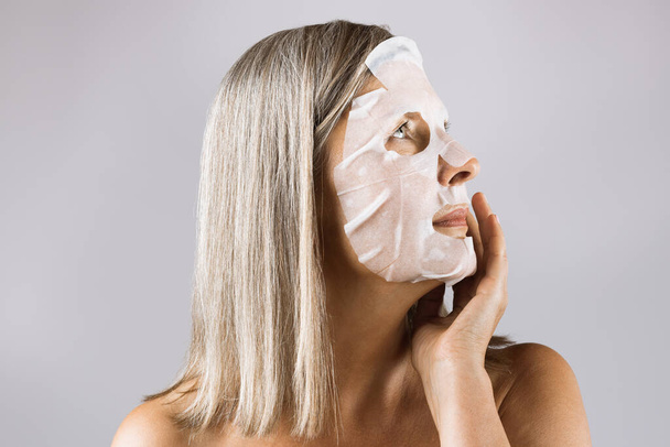 Aged caucasian woman using fabric cloth face mask - Fotografie, Obrázek