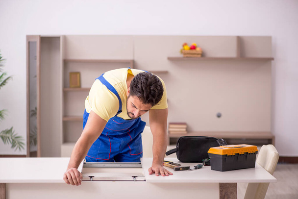 Jovem carpinteiro masculino mesa de reparação em casa - Foto, Imagem