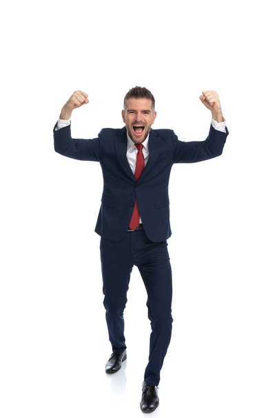 young businessman celebrating the victory with his arms up in the air and feeling excited - Fotografie, Obrázek