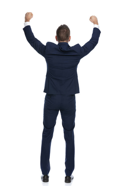 rear view of a businessman celebrating success and turning his back at the camera on white background - Photo, Image