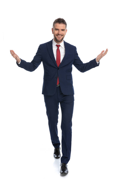 attractive businessman greeting us with open arms and a wide smile on his face against white background - Foto, Imagen