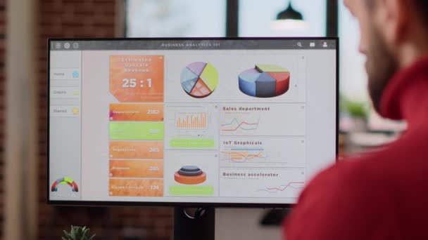 Irodai dolgozó üzleti térképeket és grafikonokat elemez a monitoron - Felvétel, videó
