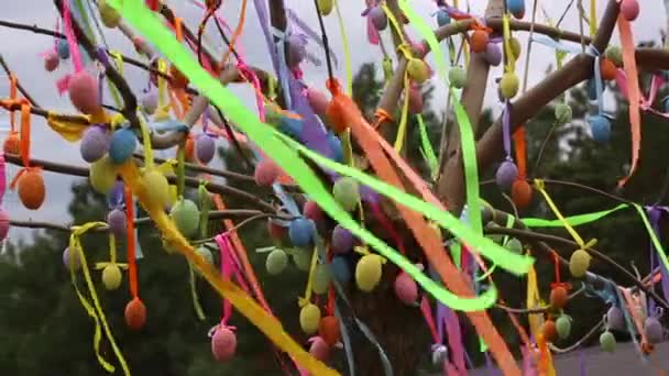 Пасхальная елка, ива украшена декоративными яйцами и цветными лентами, на фоне праздника Пасхи - Кадры, видео