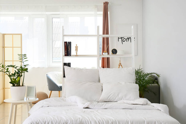 Interior of light bedroom with white bookcase - Photo, Image