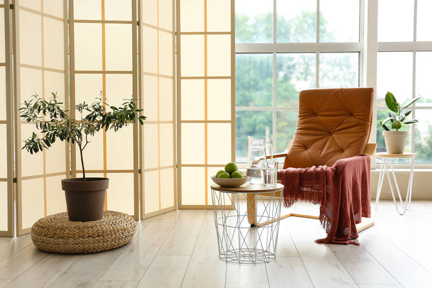 Intérieur du salon moderne avec fauteuil, table et écran pliant - Photo, image