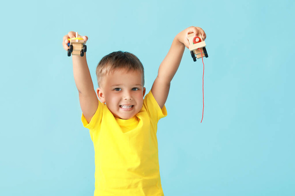 Lindo niño con juguetes de madera sobre fondo azul - Foto, Imagen