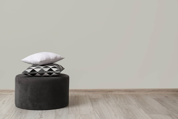 Pouf com almofadas perto da parede de luz na sala de estar - Foto, Imagem