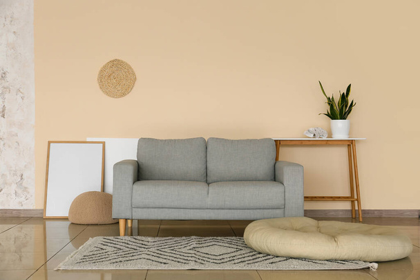 Интерьер современной гостиной со стильным диваном и фоторамкой - Фото, изображение