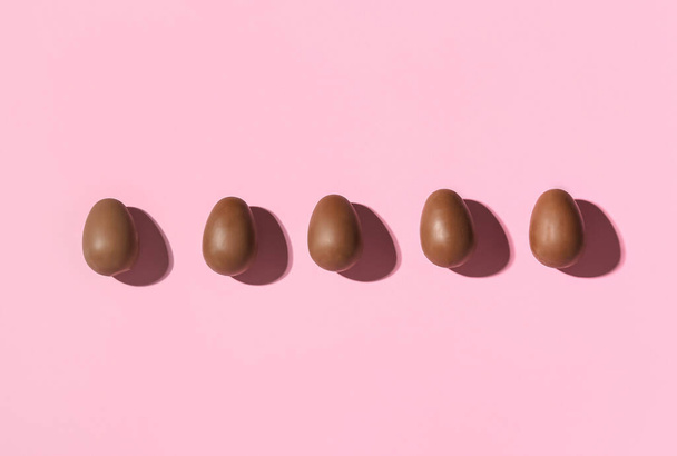 Delicious chocolate eggs on pink background - Fotoğraf, Görsel