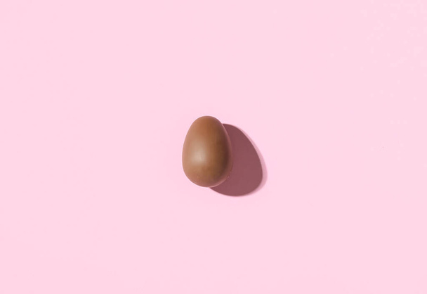 Delicious chocolate egg on pink background - Photo, Image