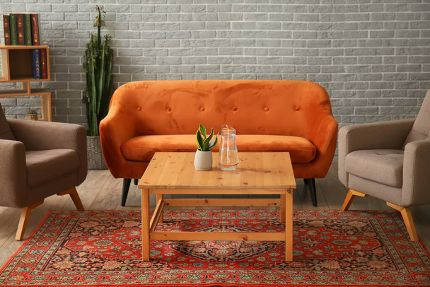 Belső tér hangulatos nappali vintage szőnyeggel, kanapéval és fotelekkel - Fotó, kép