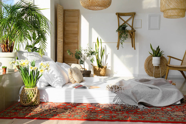 Intérieur de la chambre confortable avec plantes d'intérieur et tapis vintage - Photo, image