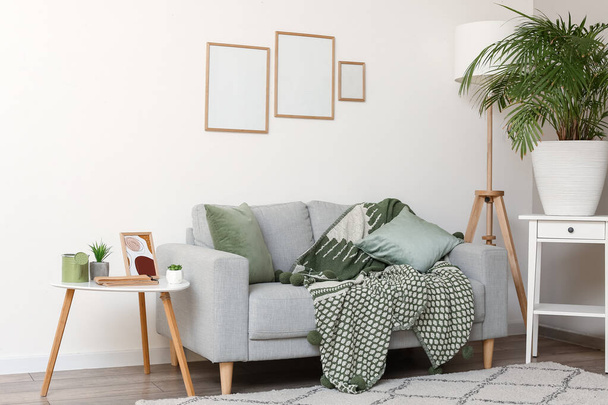 Interno del moderno soggiorno con divano e cornici bianche - Foto, immagini