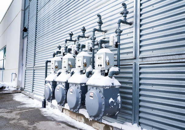 Calgary Alberta Kanada, 04. März 2022: Kommerzielle Erdgaszähler, die mit Schnee bedeckt sind, an einer Gebäudehülle. - Foto, Bild