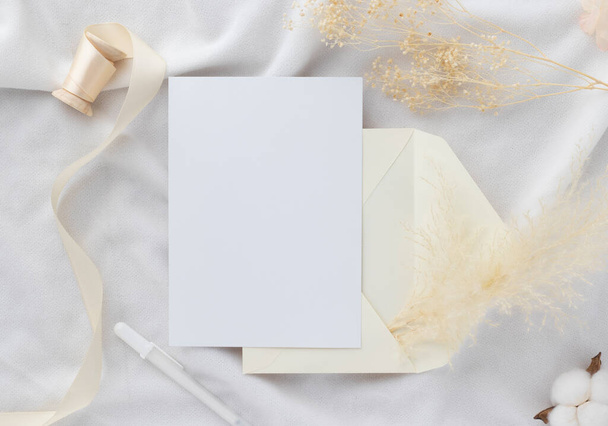 Convite de cartão de saudação em branco Mockup 5x7 no envelope com flores secas e fita no fundo de papel, flat lay, mockup - Foto, Imagem
