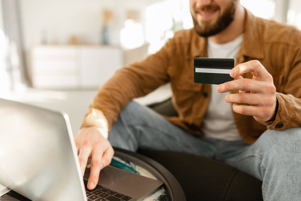 Homme méconnaissable utilisant ordinateur portable et carte de crédit Shopping à l'intérieur, recadré - Photo, image