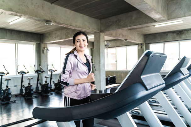 Usmívající se asijské ženy běží na běžícím pásu ve fitness sportovní tělocvična zdravý životní styl - Fotografie, Obrázek