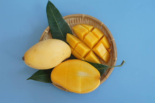 chopped mango fruits on the blue background - Photo, Image