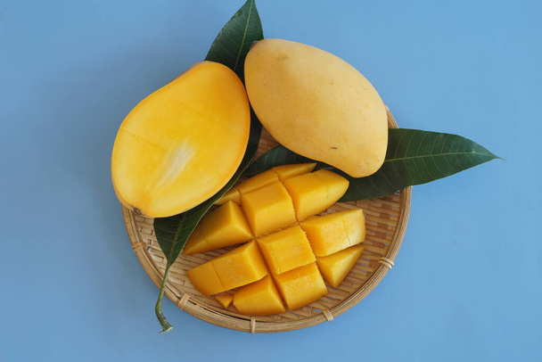 gehackte Mangofrüchte auf blauem Hintergrund - Foto, Bild