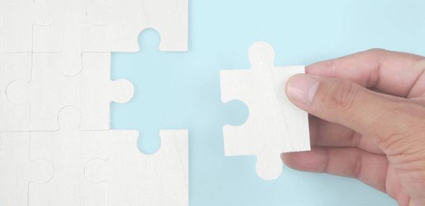 Connecting jigsaw puzzle in a hand. Business solutions success and strategy concept - Fotó, kép