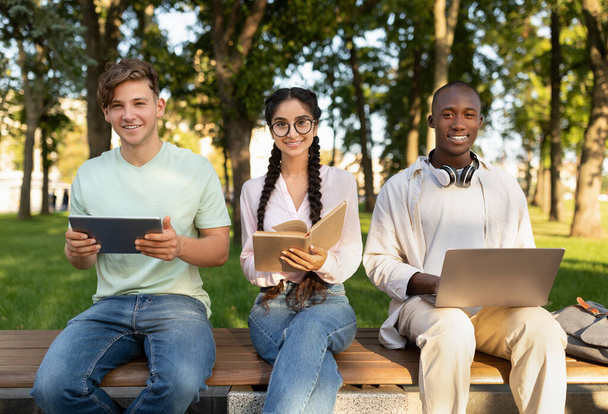 Příprava na přednášky. Happy multiracial studenti studují společně venku, pomocí notebooku, digitální tablet a knihy - Fotografie, Obrázek